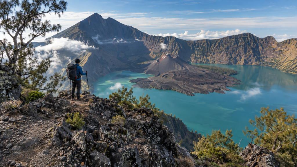 Lanskap jalur treking punggungan kawah Senaru yang memperlihatkan kaldera Segara Anak dan Gunung Barujari di kejauhan.